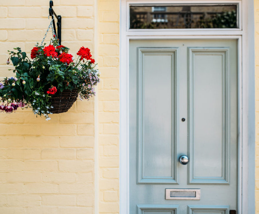 Beautiful yellow house facade with flowers hanging