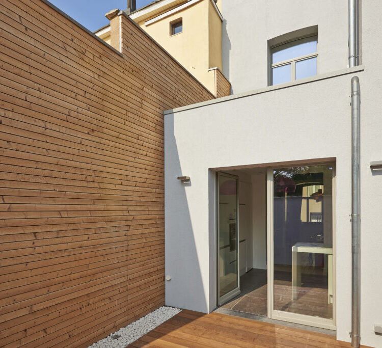 Wall construction with insulating wood cladding