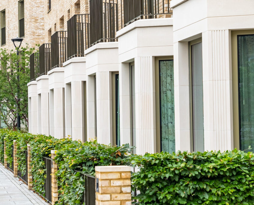 A street of modern British terraced houses, party wall